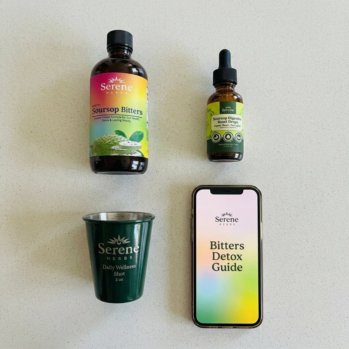 Soursop Bitters, Gut Drops, the Bitters Detox Guide on a phone and the Daily Wellness Shot Glass